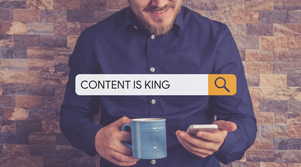 A person with a coffee searches on their phone - a superimposed search bar reads 'content is king.'