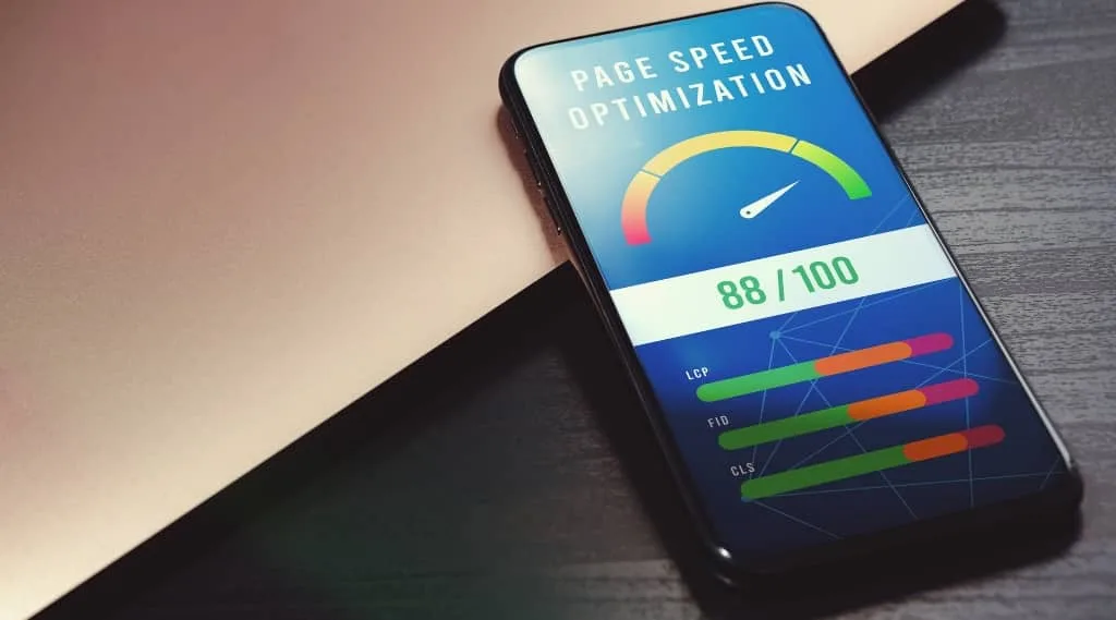 Smartphone showing 88/100 score for 7-second site speed test optimisation on a desk beside a laptop.