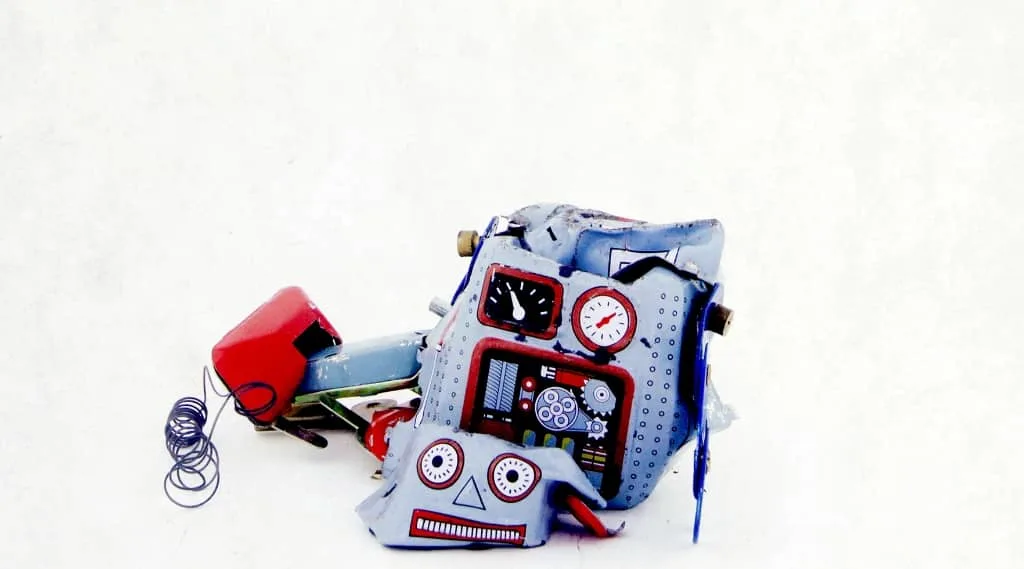Broken toy robot on a white background, symbolising the risks of AI web design without a marketing agency or proper web development expertise.